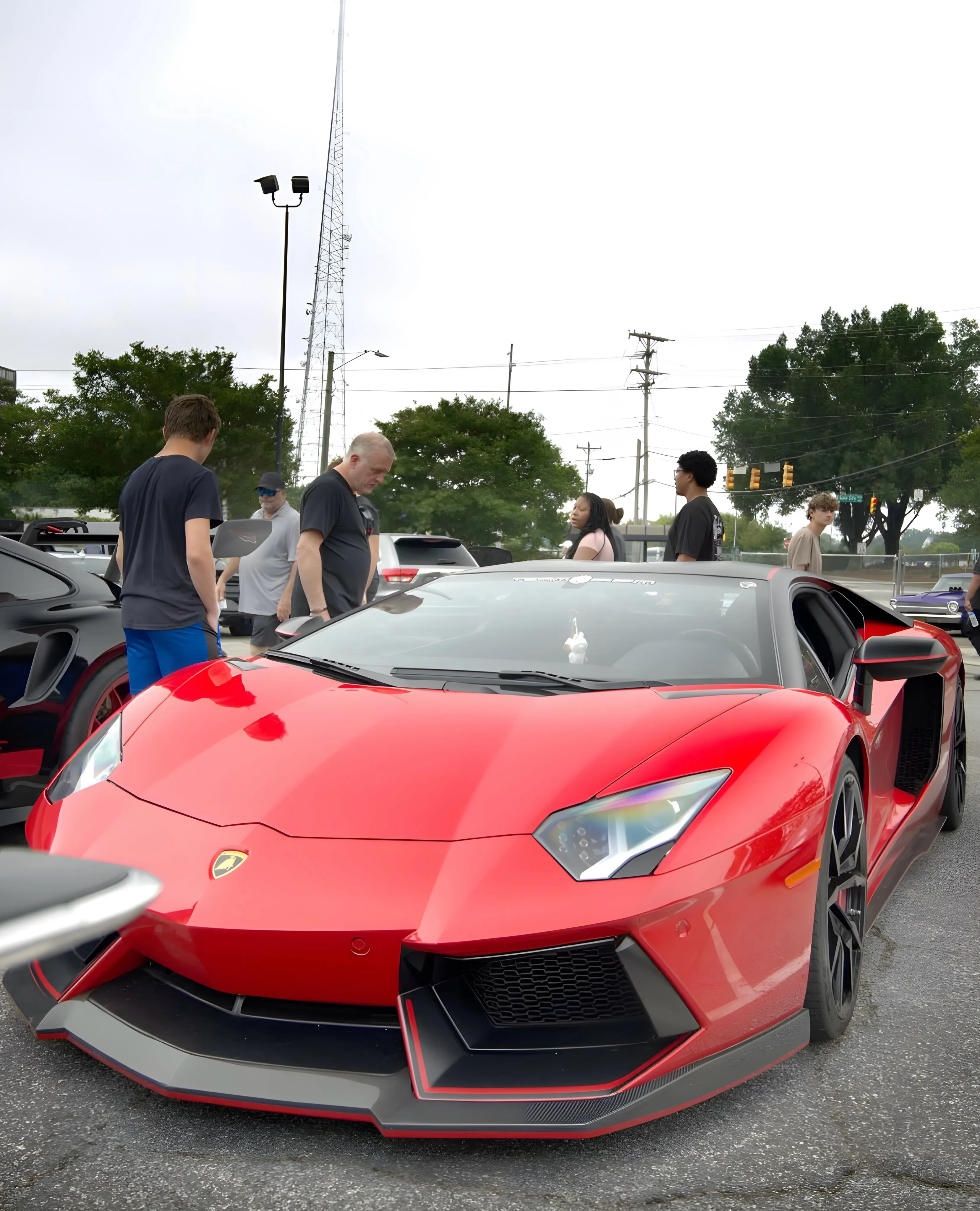 TEAM RPM members gathered around a red Aventador at a meet