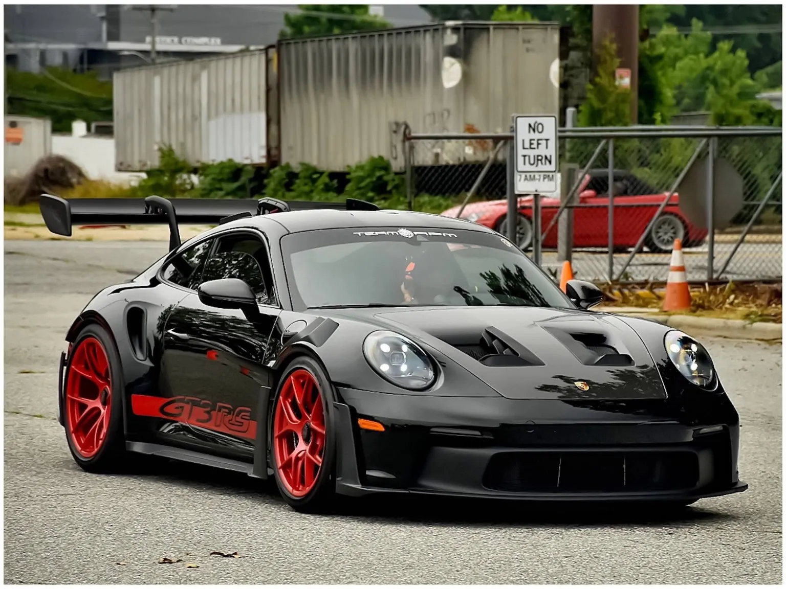 Black Porsche 911 GT3 RS on red wheels, street side