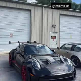 Black Porsche 911 GT3 RS in a garage with TEAM RPM context